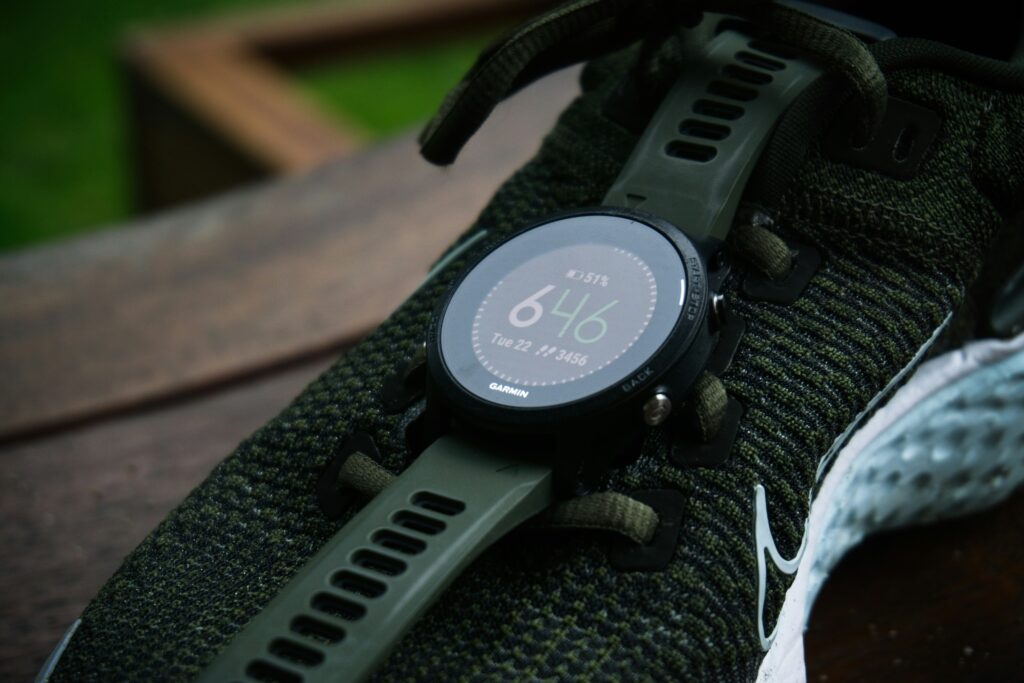 Garmin Forerunner 255 running watch on a stone showing a sleep and Body Battery screen