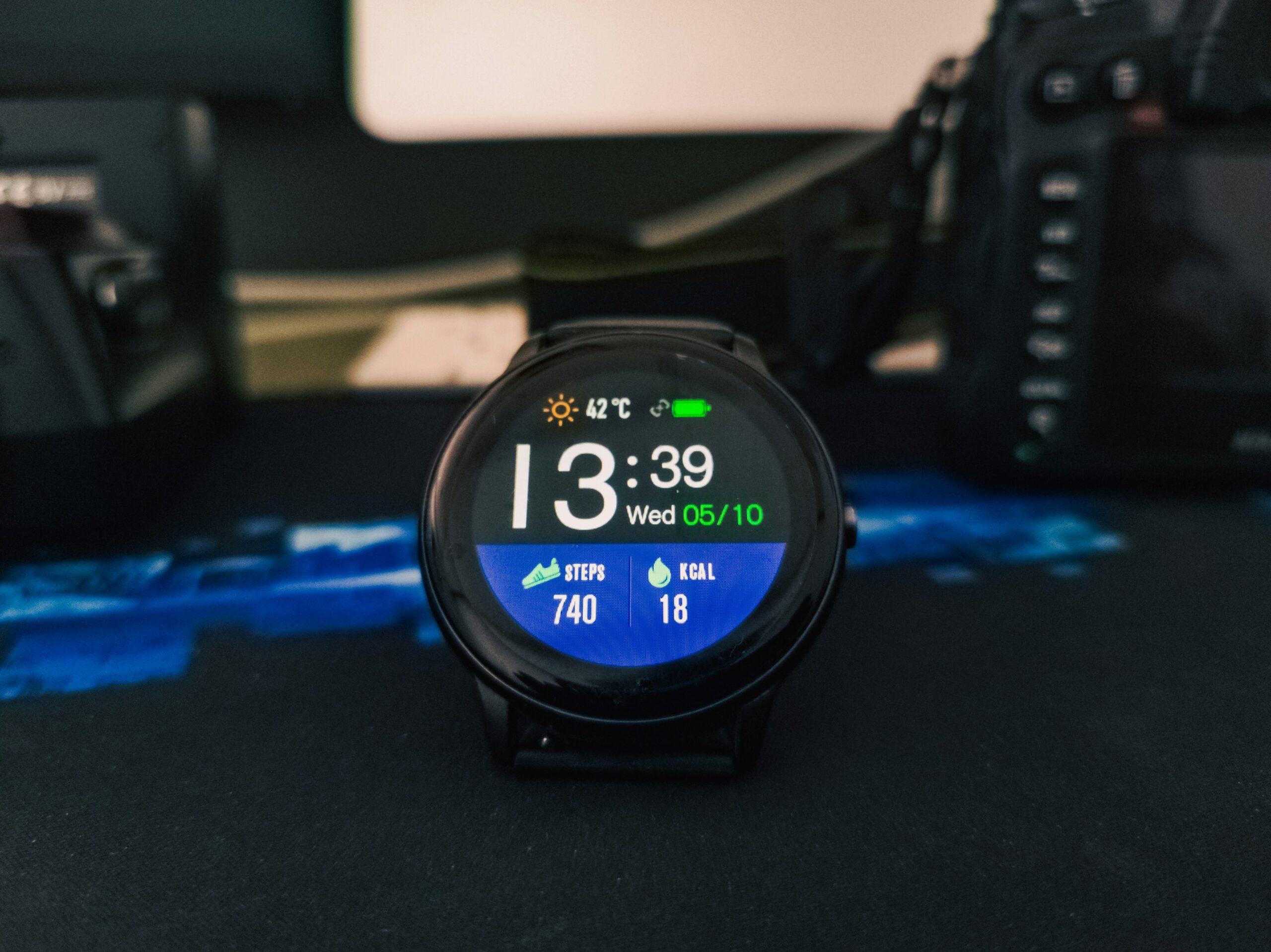 Smartwatch sitting on a charging cable on a bedside table